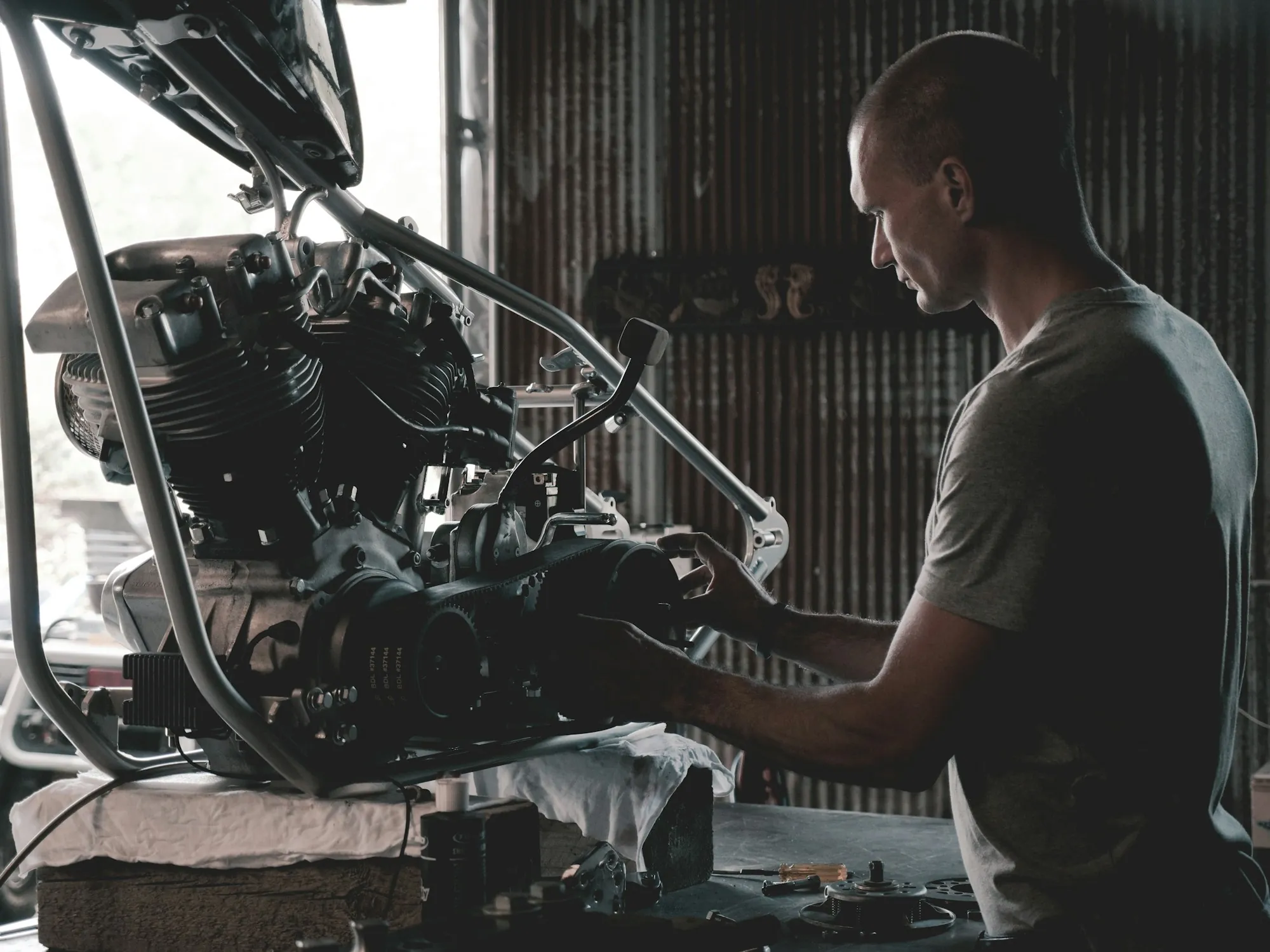 Mechanic working at a bench beside a vehicle in the shop