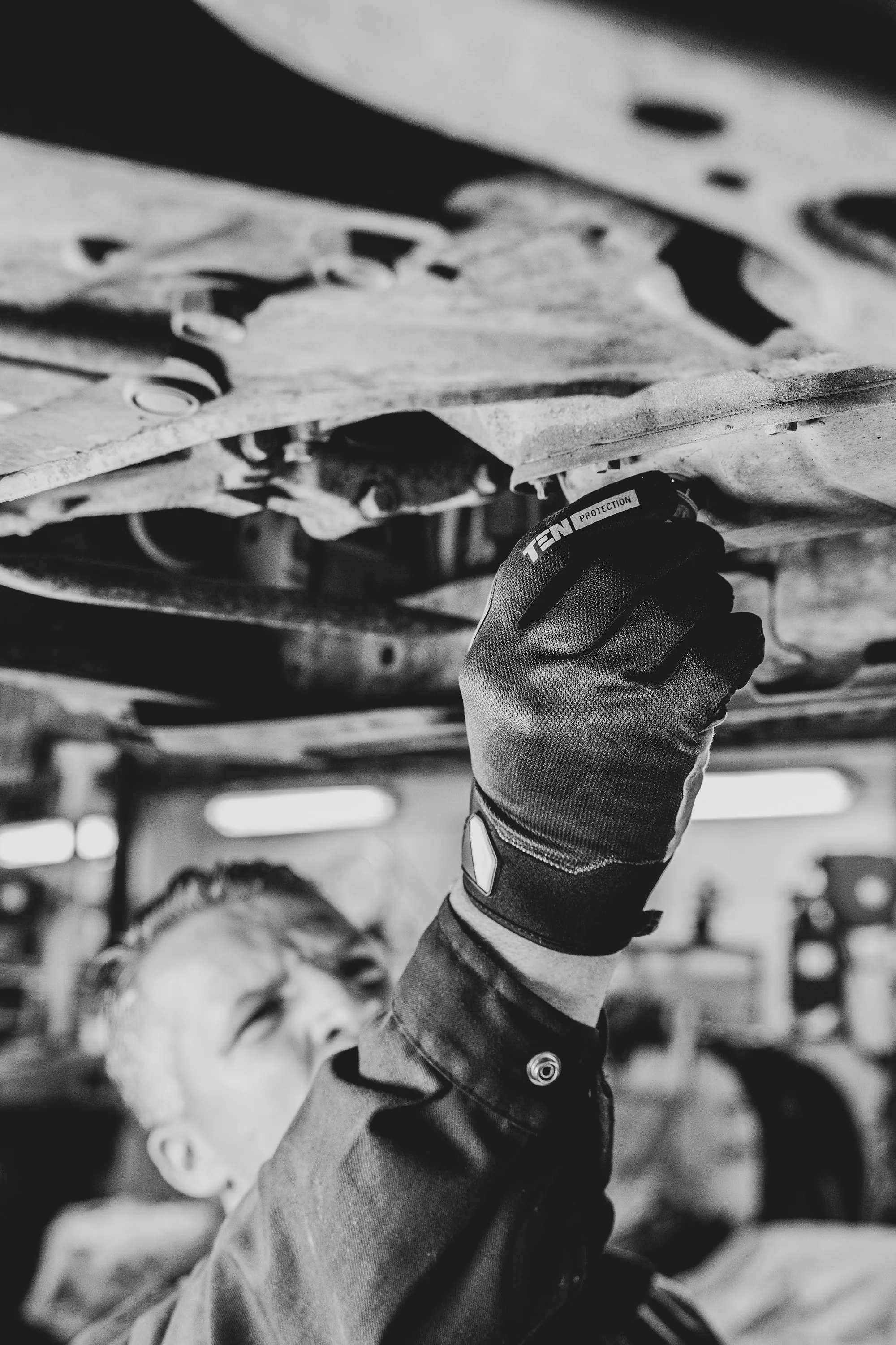 Mechanic standing beside a vehicle in a repair bay