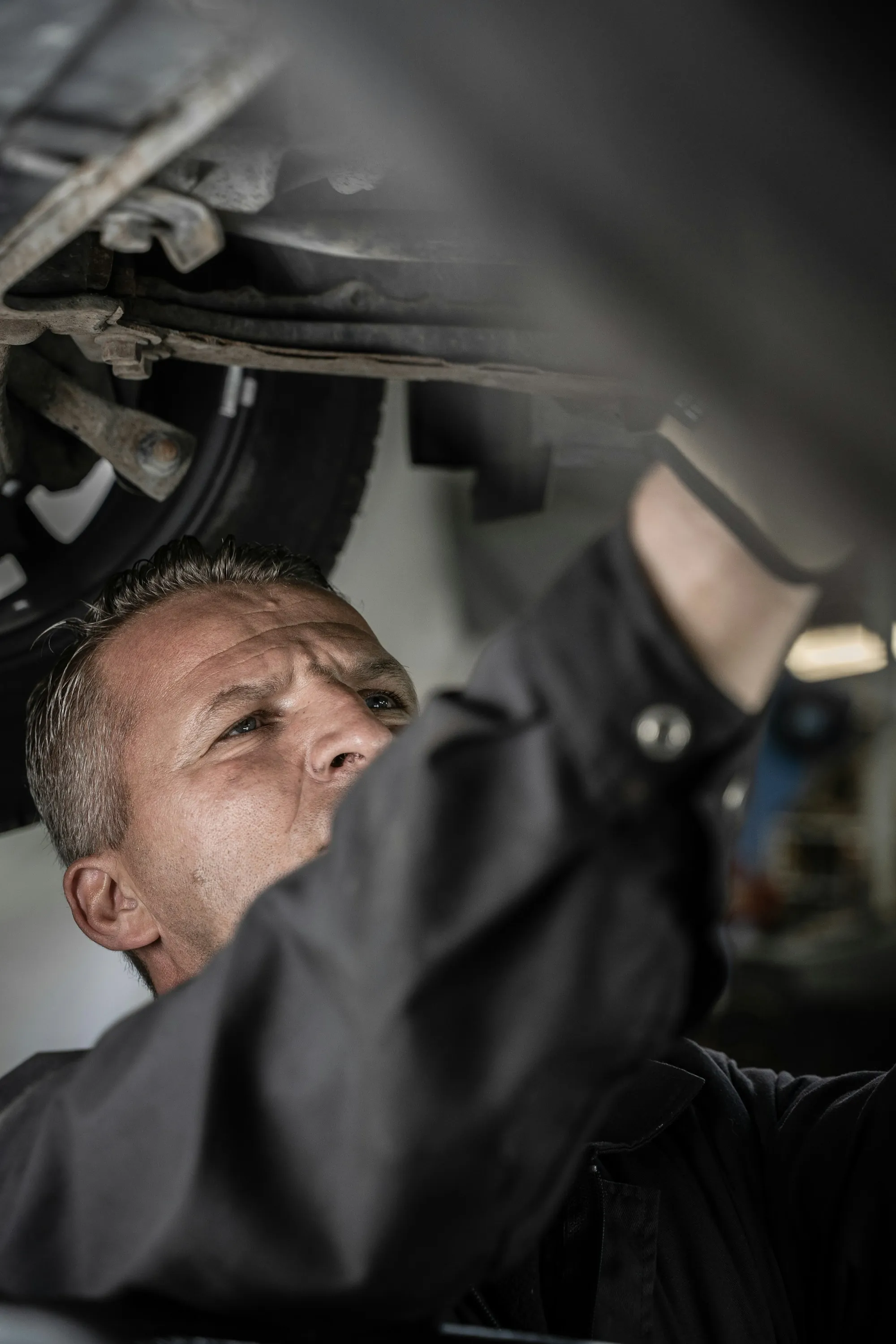 Mechanic working under a car raised on a lift